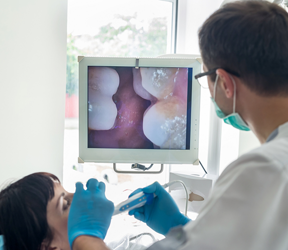 Dentist examining patient's teeth with intraoral camera