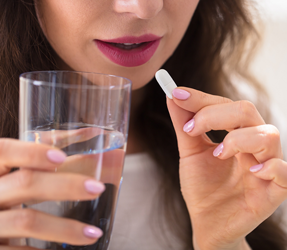 Holding pill and glass of water
