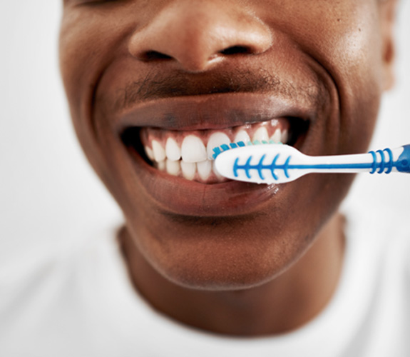 Man using toothbrush to clean his teeth